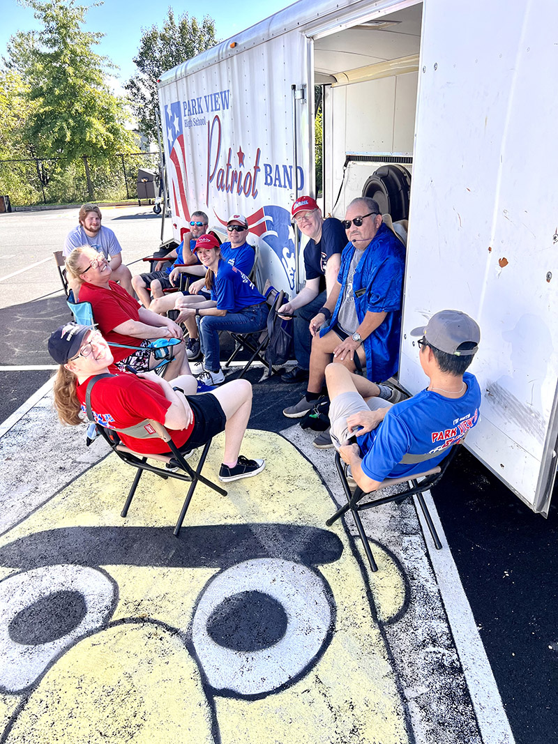 Members of the Park View High School Band Boosters assemble beside the equipment trailer.